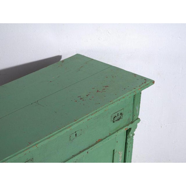 Rustic three-drawer chest in pine wood, polychromed in green and originating from the Tyrolean–Central European tradition,...