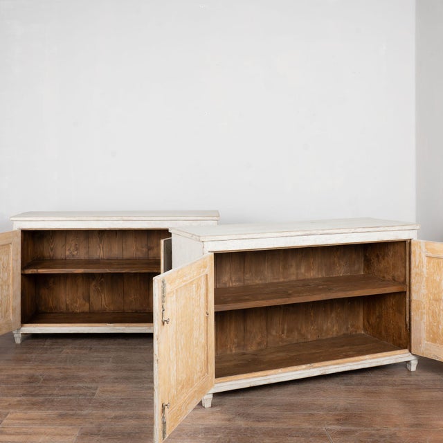 Pair of 19th century Swedish sideboards crafted in pine. Each cabinet features two doors with traditional fluted carved...