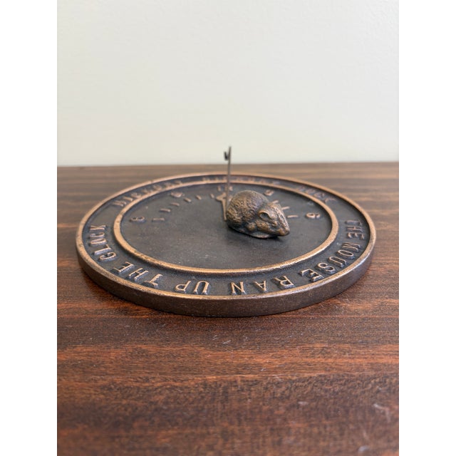 A stunning vintage bronze garden sundial featuring a charming mouse with the nursery rhyme, "Hickory dickory dock, the...