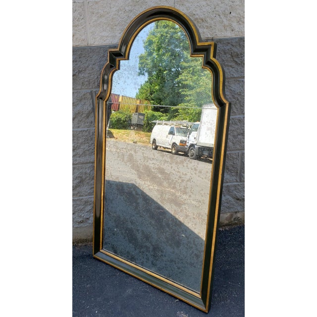 A mid century Baker Furniture Company mirror in the roman style. parcel gilt frame with dark green interior paint. Mirror...