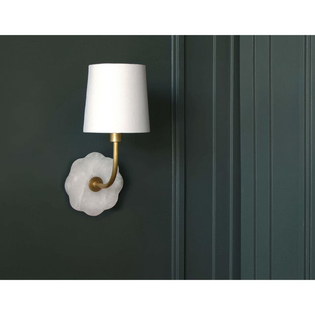 Camilla bent-arm sconce combines alabaster and natural brass for a femininely sophisticated light. The scalloped edge of...