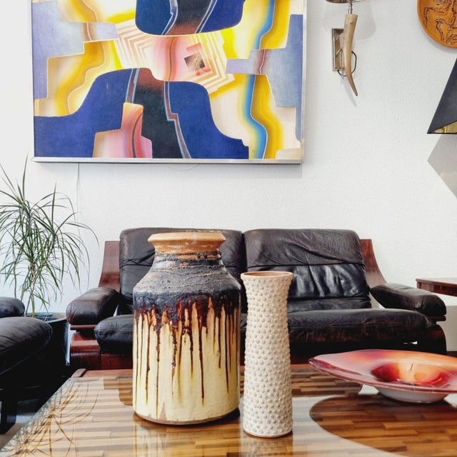 Vintage ceramic vase from the 1970s. with its beige color palette and embossed texture, it serves as a decorative...