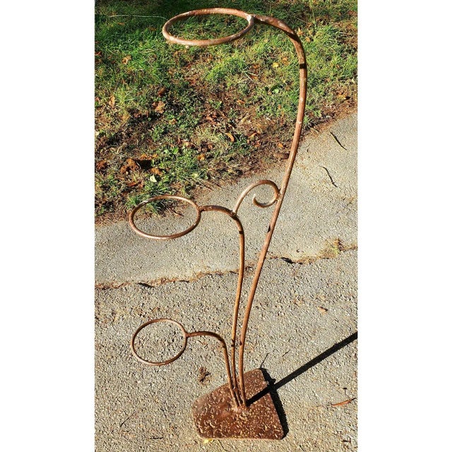 An elegant 1930s iron plant stand with heavy triangular hand wrought base.. This is pretty for a patio or balcony, or to...