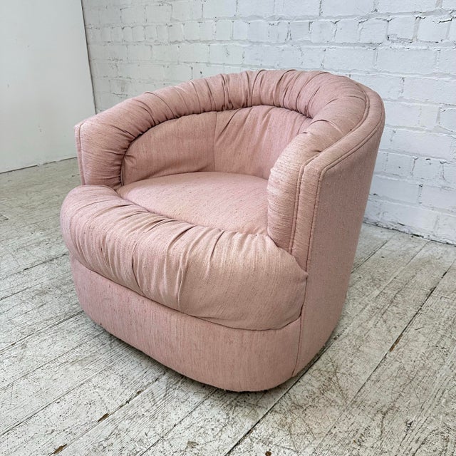This chair features a barrel shaped back with a 1980s style plush pink ruched upholstery detailing. This chair has a 360...