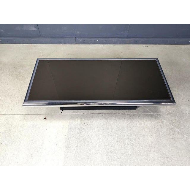 Seventies chromed metal and black glass coffee table on a black wooden base. Timeless seventies design piece. 1970s -...