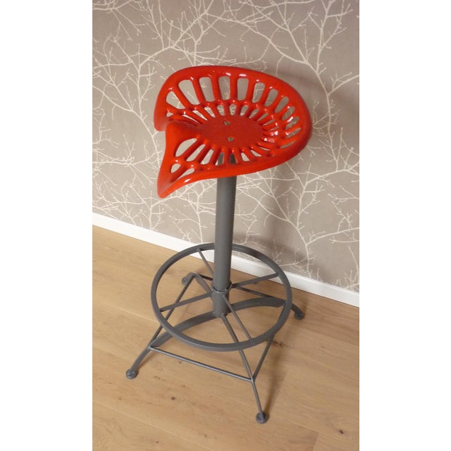 High stool with "tractor" seat style in lacquered cast iron Matt gray lacquered steel base The seat is swivel No height...