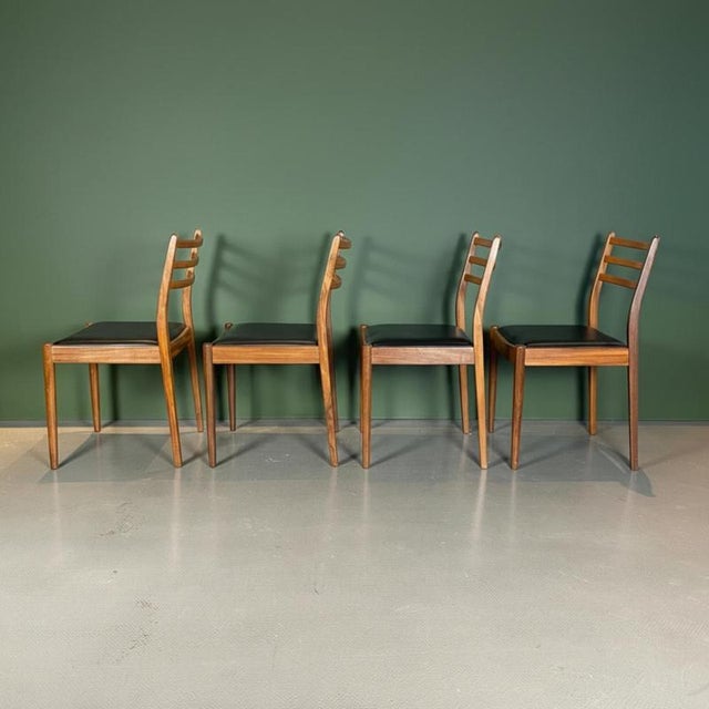 Set of 4 classic midcentury teak dining chairs designed by Victor Wilkins for G Plan with black leatherette upholstered...
