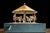 Antique hand-crank mechanical carousel toy featuring an early 20th-century carousel structure mounted on a large painted...