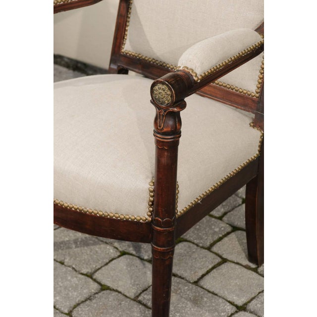 A pair of English Empire Revival upholstered armchairs from the 19th century. Each of this pair of English Empire...