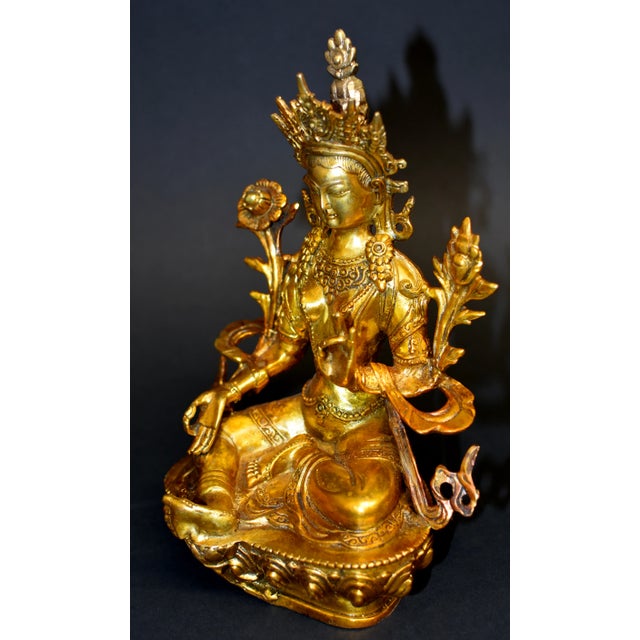 A stunning gilt bronze statue of Avalokiteshvara, the Great Compassion Green Tara. Seated in lalitasana with the right...