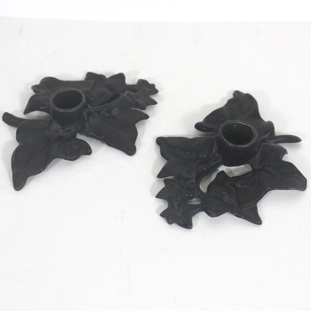 This is a gorgeous pair of vintage black cast iron candle holders in the shape of ivy leaves. They are black with a hint...