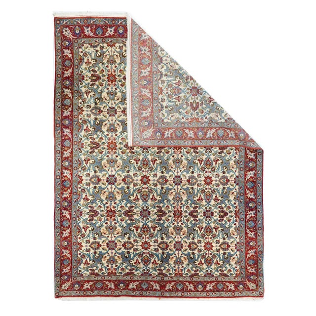 The ivory field presents seven rows of animated teal/light blue arabesques only partially tamed by rosettes and lazy...