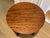 Modernist round wooden table with distinctive wavy grain patterned top, lower shelf and rounded ball feet. Species of...
