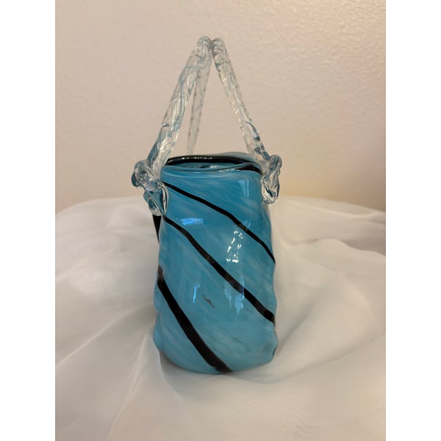 This teal and black swirled Murano style hand blown purse has a overlap flap with a big black button on it which just...