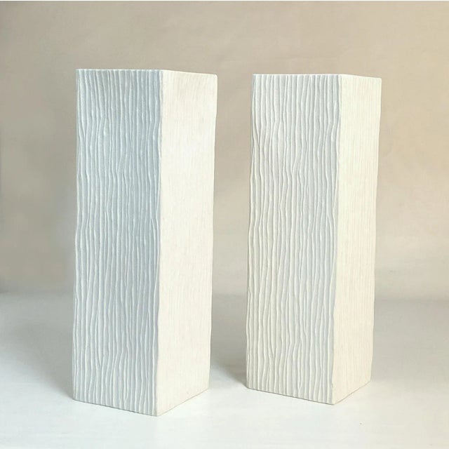 Pair of tall white porcelain square vases with vertical relief surface, by Hutschenreuther Germany, 1960s. This piece is...