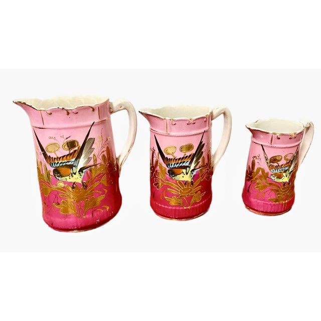 Vibrant and unique trio of bird vases in descending sizes. Dynamic tones and style, bright pink ground with gilt edging....