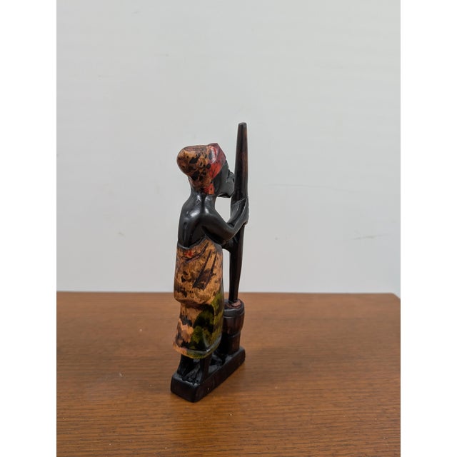 Masterfully hand-carved in Ghana, this striking one-of-a-kind sculpture captures an African woman engaged in the...