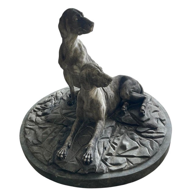 A monumental cast marble group depicting two hunting hounds , likely pointers or scent hounds ,rendered with remarkable...
