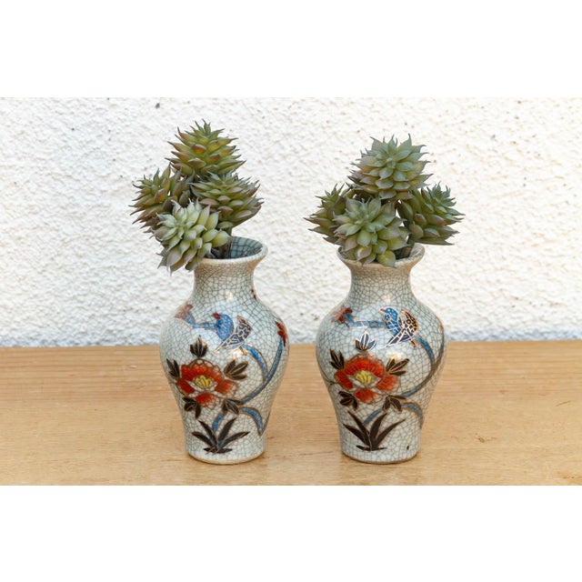 This pair of miniature jars is a fine example of traditional East Asian ceramic techniques, featuring a classic crackle-...