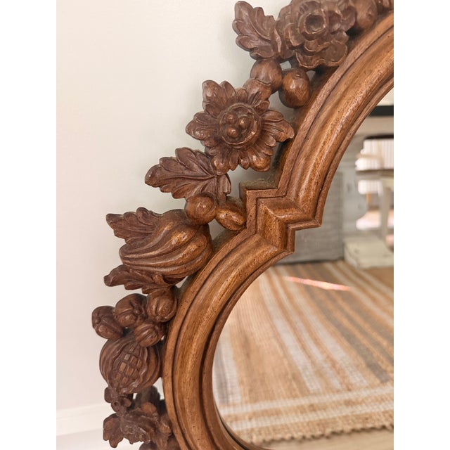 Striking vintage walnut wall mirror featuring an ornate dimensional frame richly decorated with carved fruit, flowers,...