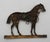 Gilt bronze horse silhouette, late 19th-early 20th century, Anglo-American. Horse standing in a leafy pasture with saddle...