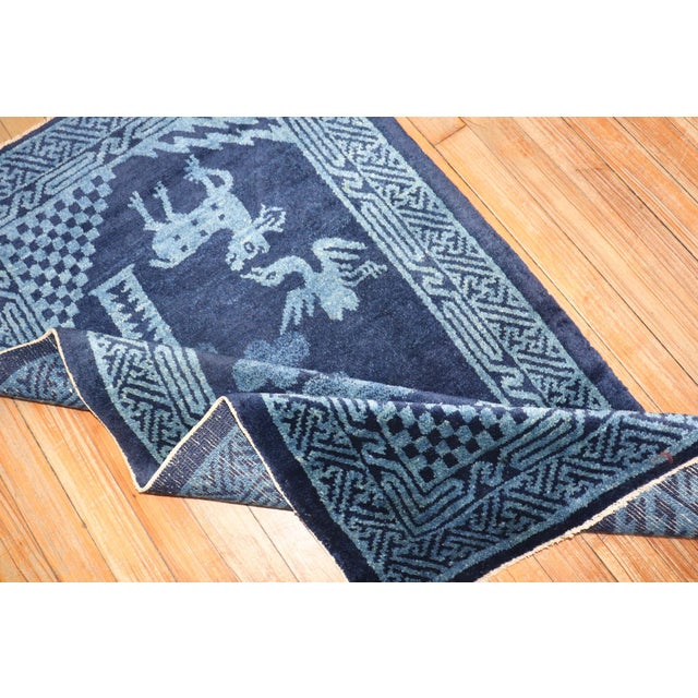 A Chinese peking carpet in midnight blue with a pictorial animal motif. Measures: 2'3'' x 4'.