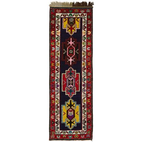 This exquisite runner rug is a rare example of tribal craftsmanship, hand-knotted by the women of the Herki tribe during...