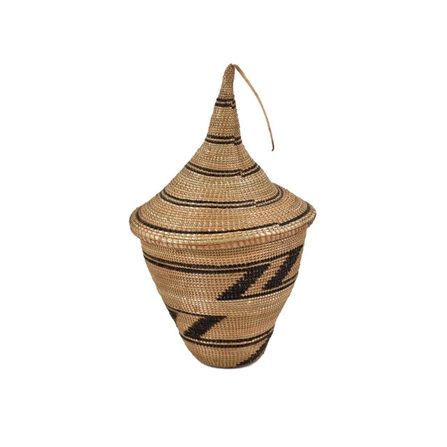 The Tutsi Tight Weave Basket with Lid from Rwanda epitomizes the artistry and tradition of the Tutsi community's weaving...
