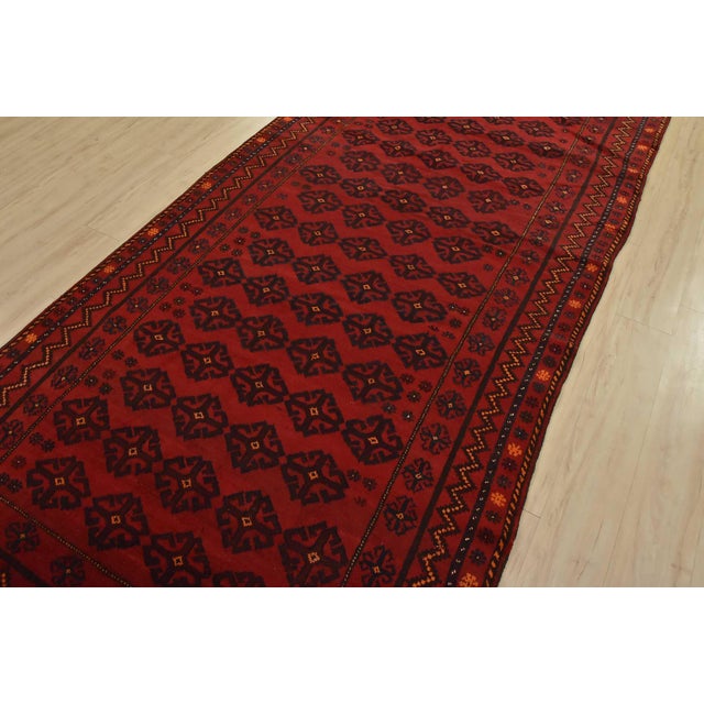 An authentic vintage tribal Baloch rug hand-knotted with fine wool and natural dyes. This nomadic rug features geometric...