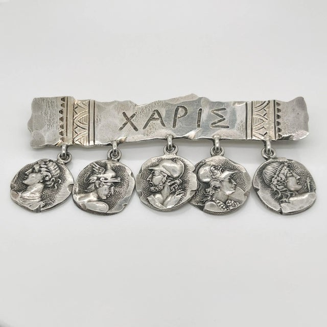 A very fine George Shiebler Etruscan brooch. In sterling silver. With five medallions suspended from a bar stamped XAPIE....