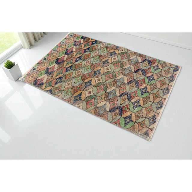 This is a vintage Turkish Oushak rug from the Mid 20th Century. The piece was hand-knotted.