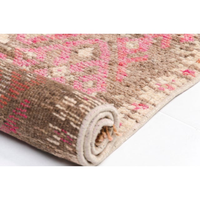 This is a vintage Turkish Oushak rug from the Mid 20th Century. The piece was hand-knotted.