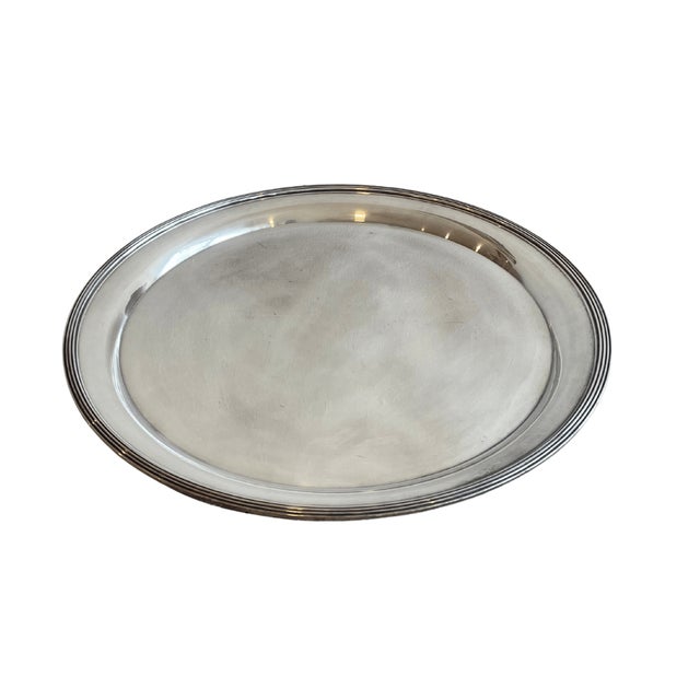 A vintage large round silver-plated serving tray with a clean polished center and elegant reeded border. Generous in scale...