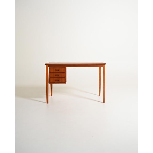 Teak desk with a floating three-drawer chest and square legs. Scandinavian production, 1960s. Light proportions and a...