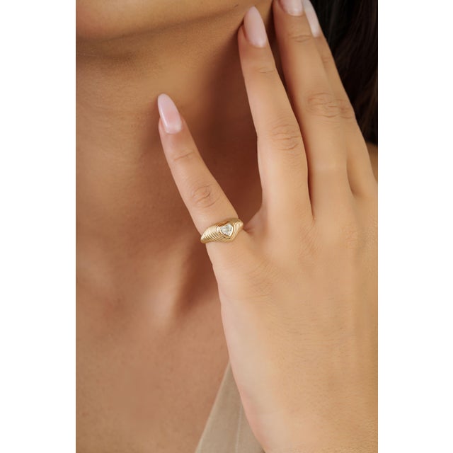 This bold pinky dome ring features a 0.61 carat heart-cut diamond set in 14k yellow gold. The diamond measuring...