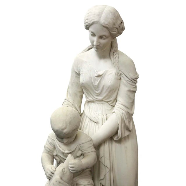 Charming white marble sculpture made in Italy in the 19th Century. The central focus is a graceful mother, draped in...