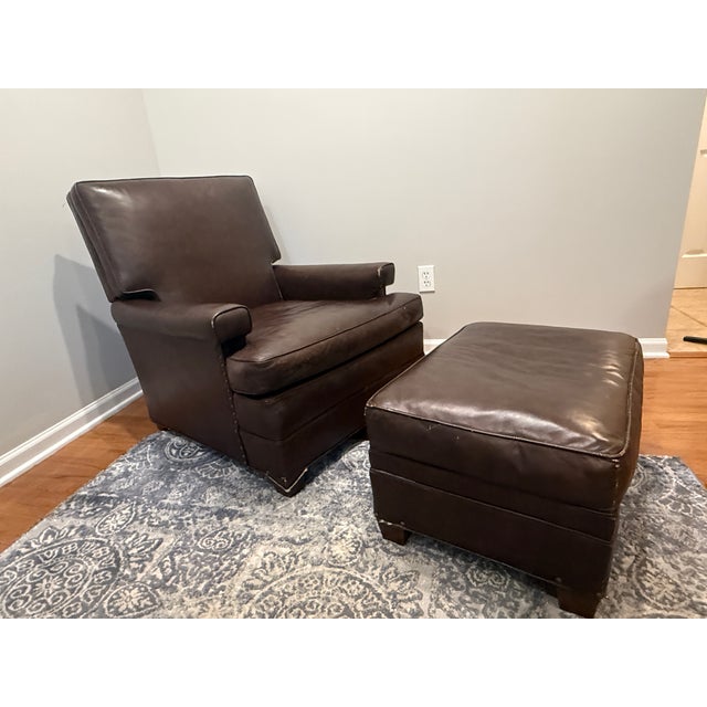 A striking two-piece vintage dark brown leather push-back reclining lounge chair and matching ottoman set by the Kittinger...