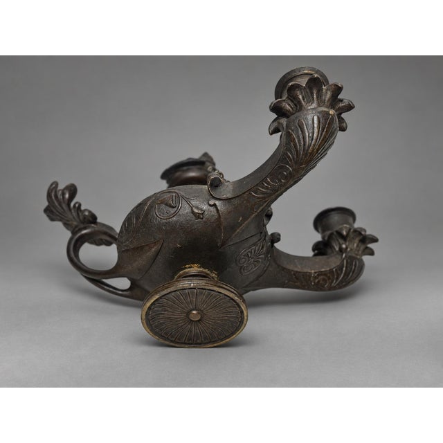 Pair of Grand Tour Bronze Two-Light Candlesticks in Roman Oil-Lamp Form A pair of patinated bronze candlesticks, probably...