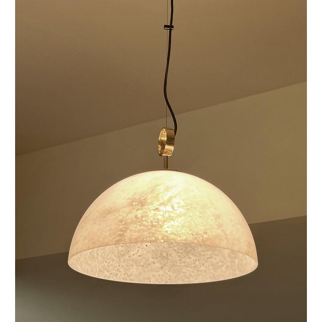 Large Vintage Limburg pendant light, featuring an hemispheric mottled murano glass shade mounted on a brass pendant with...