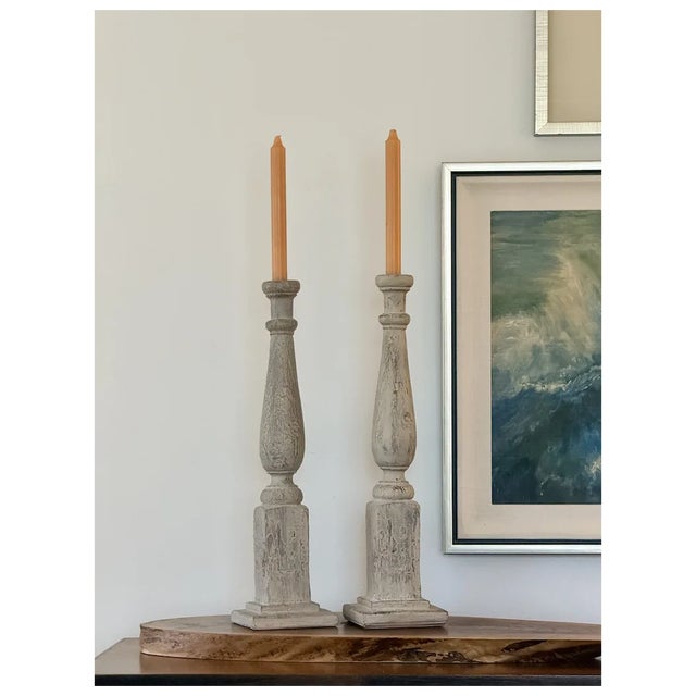An impressive pair of tall architectural candlesticks with a beautifully weathered, old-world finish designed to resemble...