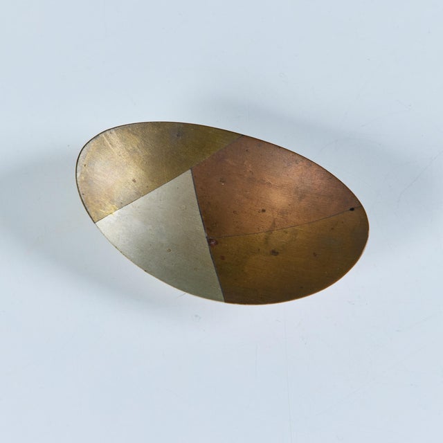Oval Mexican dish made of copper, brass and stainless steel. The dish rests on three spherical brass ball feet. Stamped...