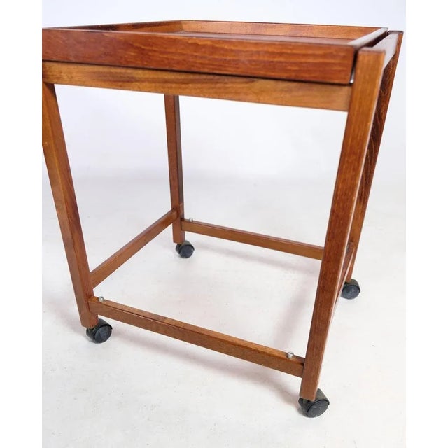 Small round coffee tables with 4 wheels and a serving tray both above and below made in walnut from around the 1960s....