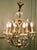 A Charming French Crystal and Brass Chandelier The elegant brass frame of this light forms a cage shape with the branches...