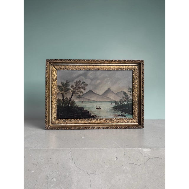 A charming antique American folk art landscape depicting a tranquil mountain lake with small fishing boats, rocky...