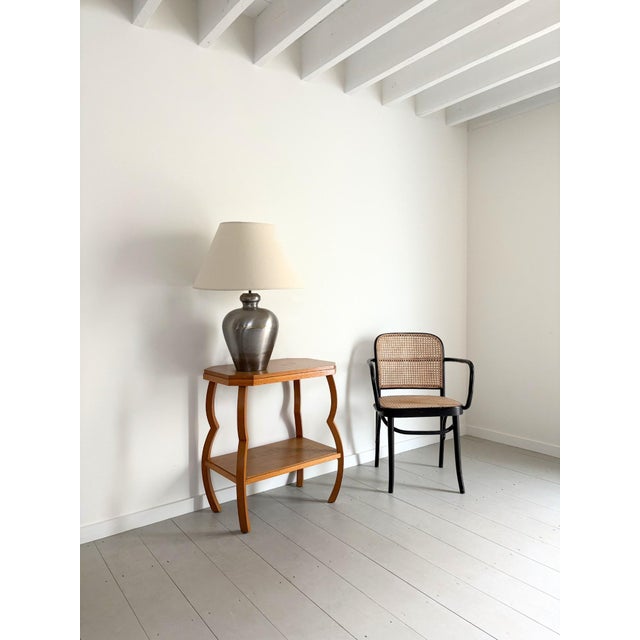 A large vintage table lamp in polished metal with brass infill accents around the diameter and an antique brass riser. The...