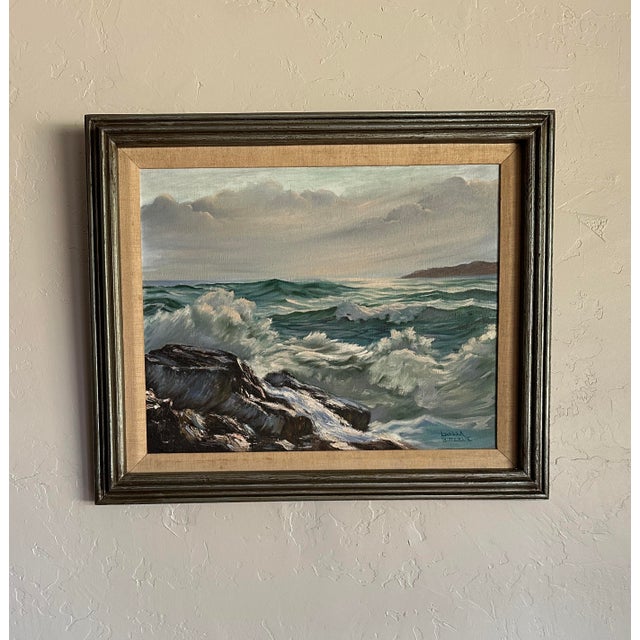 This vintage 1980s oil painting of a seascape by Luella Bitterlie depicts crashing waves against a rocky outcropping. The...