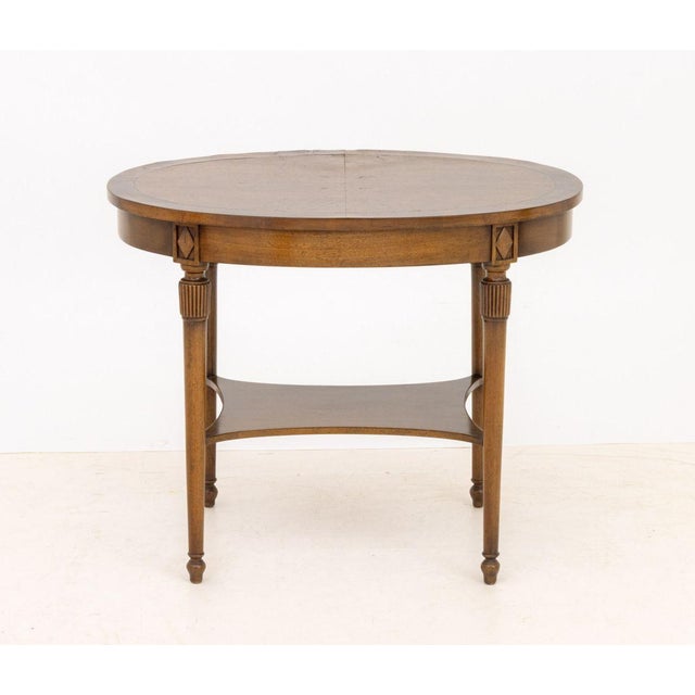 American Oval Walnut Occasional Table, with four legs conjoined by an undertier, Beacon Hill label to the underside of...