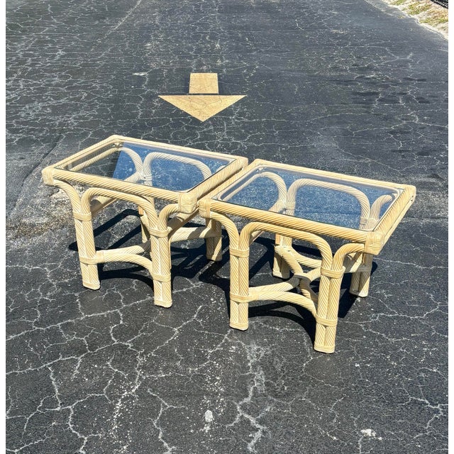 A sculptural pair of vintage coastal end tables featuring thick spun rattan construction designed to resemble twisted...