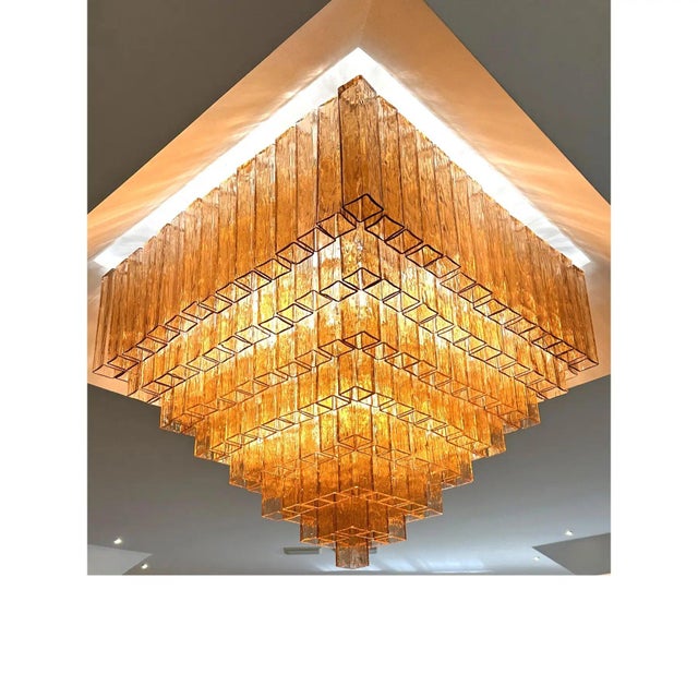 Elegant luxury flush mount made in amber-rosè murano glass “squared” elements. “squared ” are blown inside a wooden mold,...