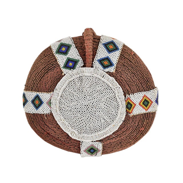 Married Zulu women always keep their heads covered in public. For ceremonial occasions, they wear elaborately woven red...